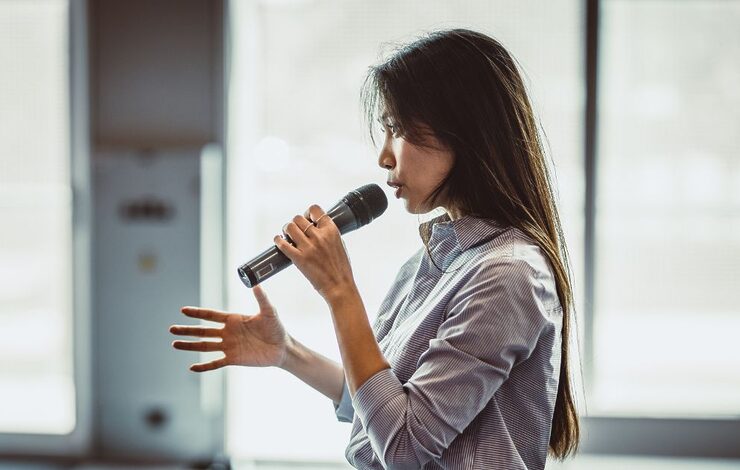 a speaker at a conference with a microphone in their hand
