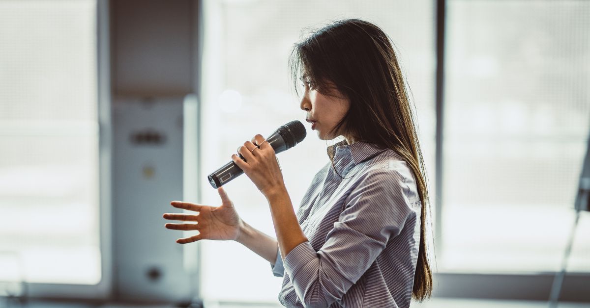 a speaker at a conference with a microphone in their hand
