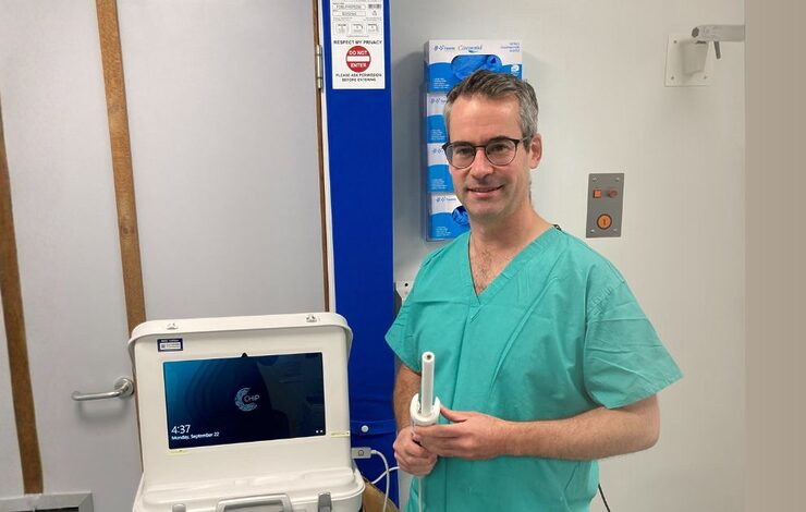 Mr Peter Vaughan-Shaw, Consultant Colorectal Surgeon at the Western General Hospital, standing beside a Lumeneye machine
