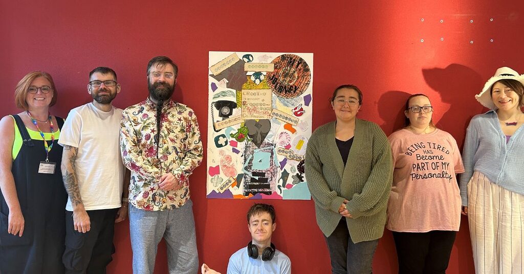 Young adult renal support worker with patients in front of their exhibition artwork