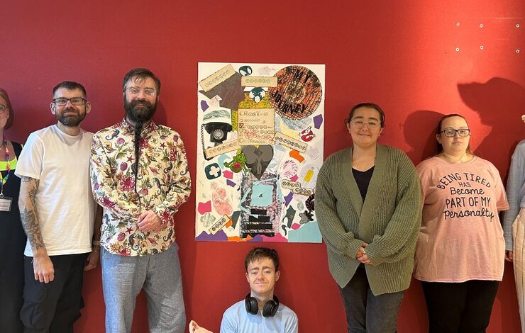 Young adult renal support worker with patients in front of their exhibition artwork