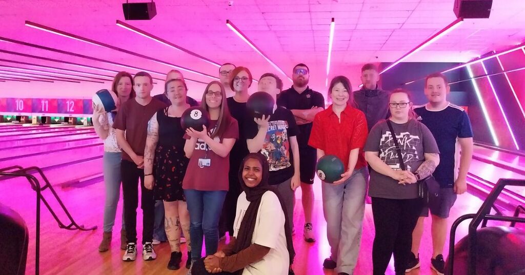 Young adult renal support worker with patients at bowling alley