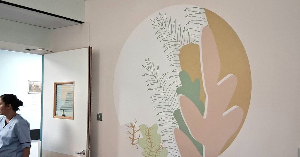 wall vinyl enhancement in a hospital room with a member of staff at the door