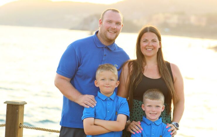 Kelsey Hodgson, her husband David and their two sons facing the camera and smiling