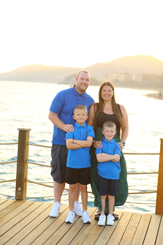 Kelsey Hodgson, her husband David and their two sons facing the camera and smiling
