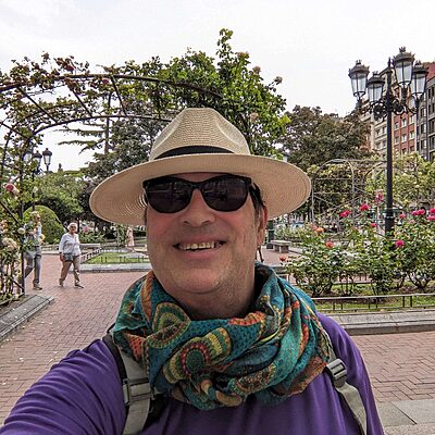 Alan McEwan walking the Camino de Santiago smiling for the camera in his NHS Lothian Charity t-shirt