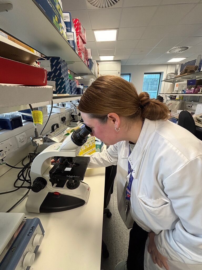 Charlene looking through the microscope