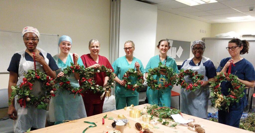 Staff holding up their festive garlands at the Royal Infirmary