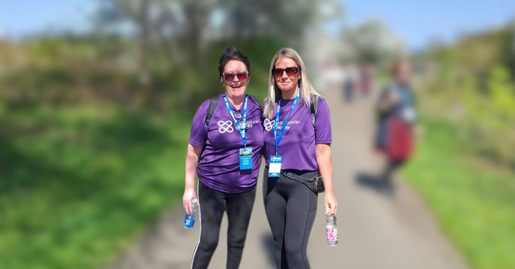 Carly and Bev smiling at the camera in NHS Lothian Charity t-shirts