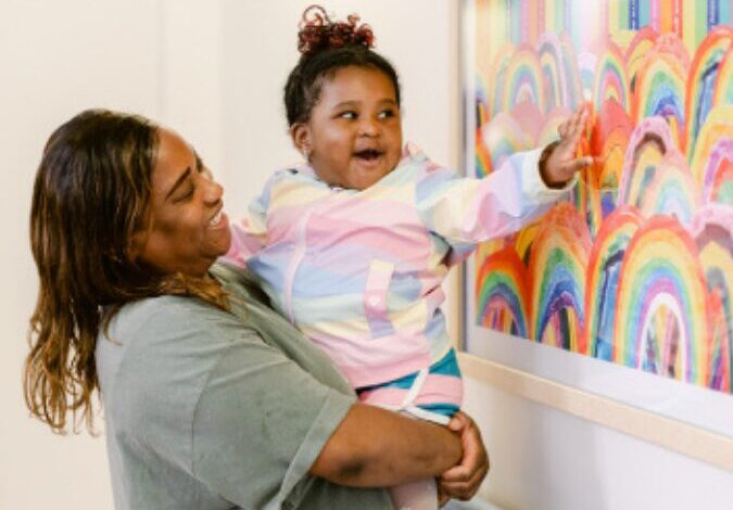 Lady holding her daughter looking at art