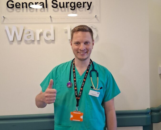 Daniel smiling with thumb up, staff lottery winner