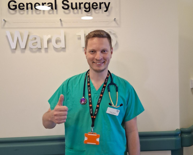 Daniel smiling with thumb up, staff lottery winner