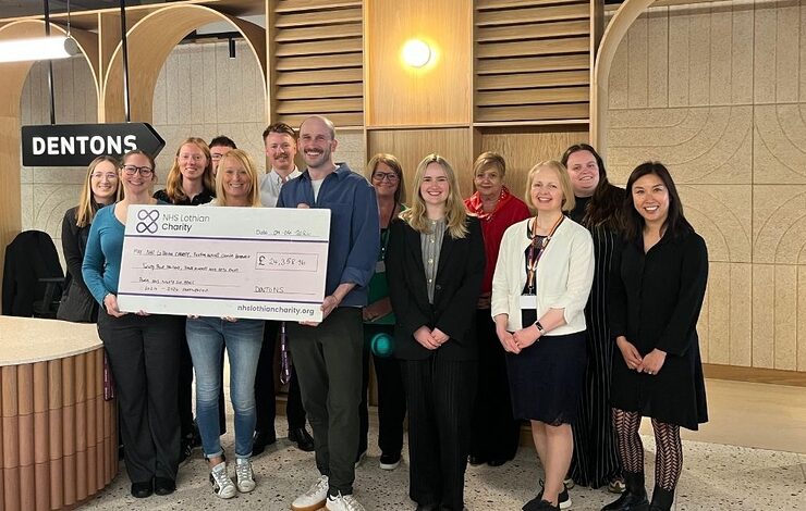 staff from dentons holding a large cheque
