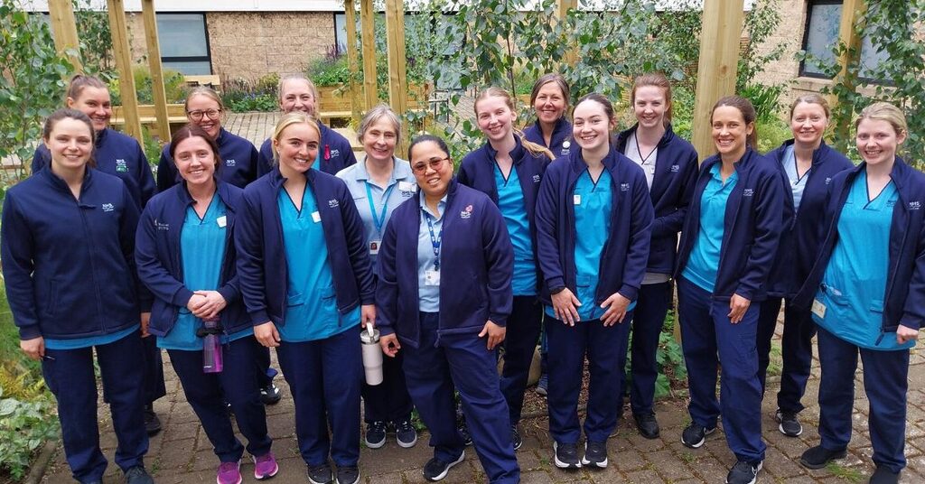NHS Lothian staff members standing facing the camera in the staff wellbeing courtyard at the Royal Infirmary of Edinburgh